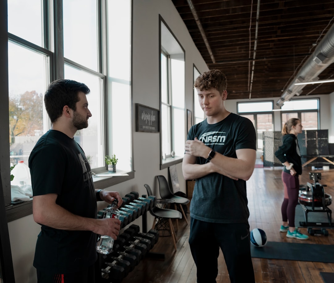 a-man-standing-next-to-another-man-in-a-gym-kvjyluxk4hq